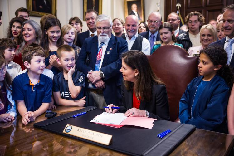 Surrounded by children and state legislators, Gov. Kelly Ayotte signs the Parental Rights HB 10 bill at the Executive Council chambers on Tuesday, June 10, 2025.