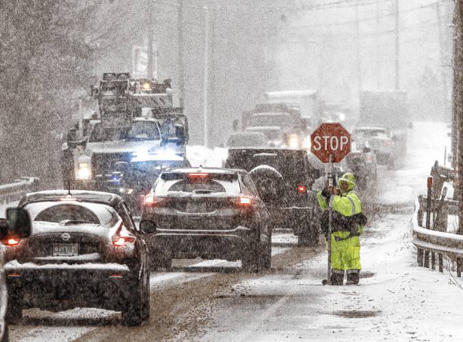 Flagger Dianna St. Laurent directs traffic for a communications company that was working on lines along Route 3 in Tilton during the snowstorm on Tuesday, January 16, 2024. St. Laurent traveled from Pittsfield in the snow for the work.