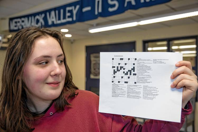 Merrimack Valley senior Natalie DeGreenia holds up one of her crossword puzzles she has created for her senior project on April 3 in the foyer of the school.