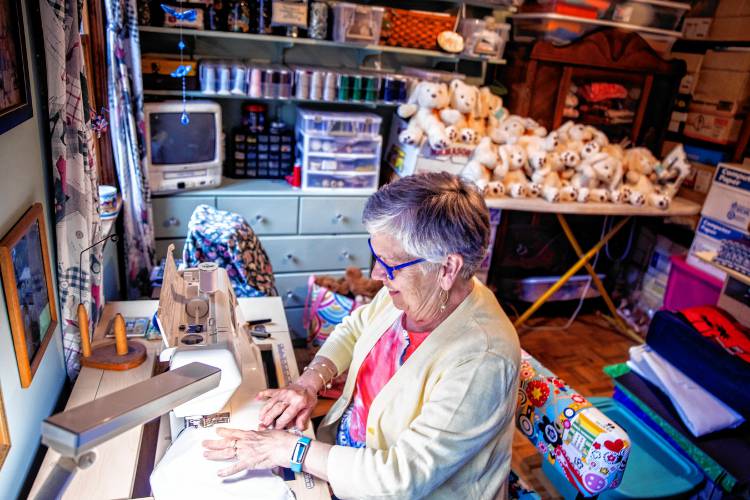 Nancy Peperissa in her sewing room in her Penacook home where she puts the finishing touches on making skull caps for chemotherapy patients and filling teddy bears with rice to comfort Alzheimer patients.