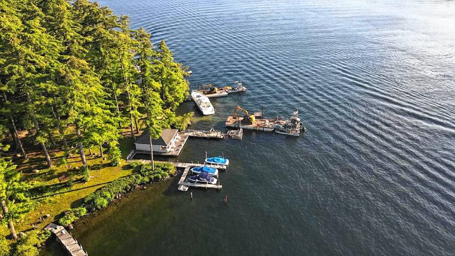 Drone photos taken last year show barges attempting to remove the blue, 50-foot Sea Ray from its perch on the rocks near Keewaydin's beach. 