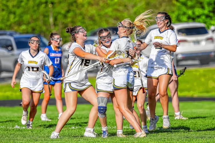 From left to right: Ella Gray (18), Kendall Murray, Olivia Selleck and Charlotte Duncan (5) surround Murray after she scored the game-winning goal in overtime against Londonderry on Thursday, May 23, 2024.