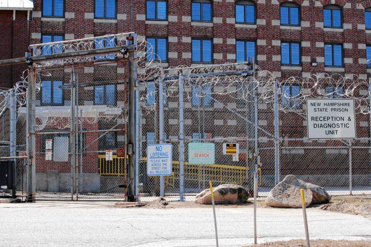 Razor wire hangs from the fence at the reception area at the New Hampshire State Prison for Men in Concord, N.H., Tuesday, March 31, 2020.