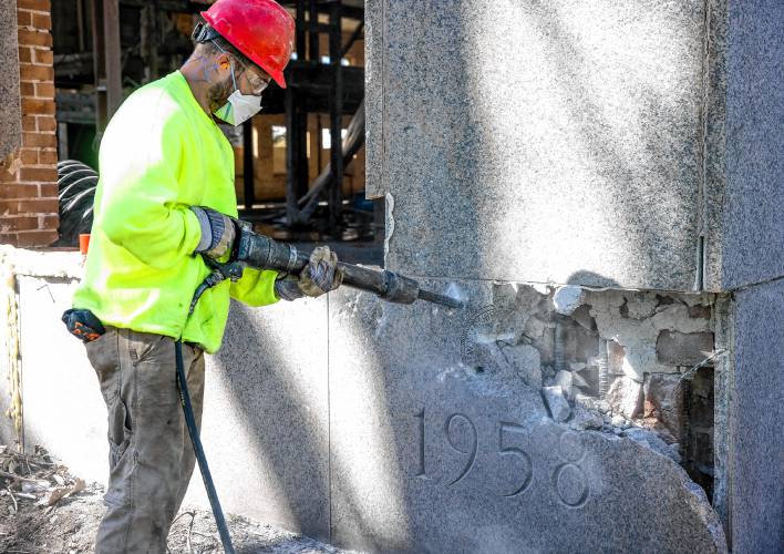 A member of the S&R Demolition team out of Lowell, Massachusetts use an hammer to chip away at the cornerstone of the former DOJ and Mechanics Bank building on North State Street as they search for the time capsule on Tuesday, April 9, 2024.