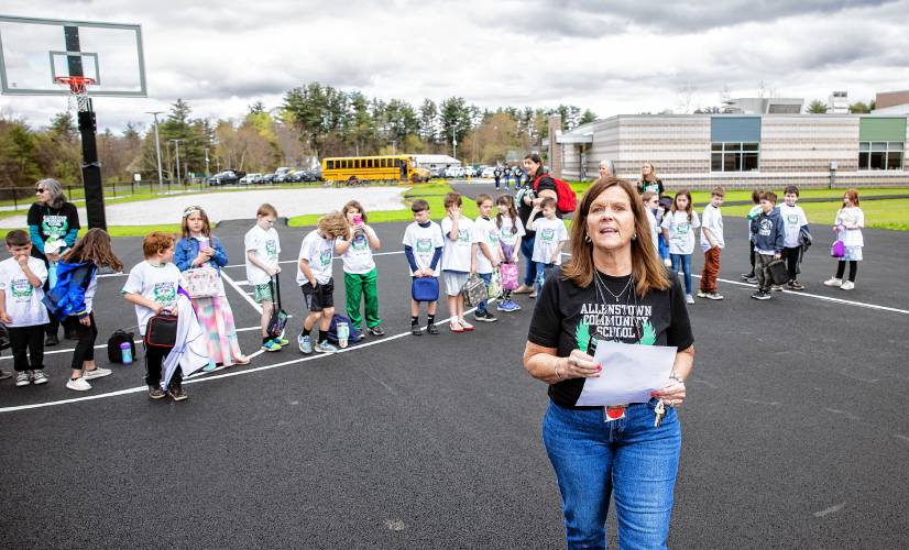 Allenstown Community School Principal Shannon Kruger directs as students and faculty gather for a drone photo outside the school on the first day of classes at the new facility.  Faculty wore black tee shirts commorating the first day of school and the students wore white tee shirts given by a school employee.