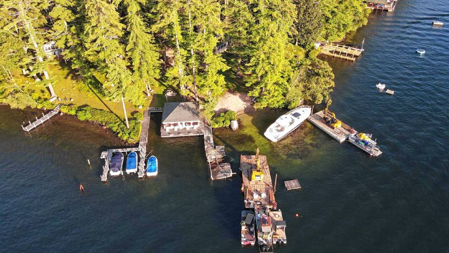 Drone photos taken last year show barges attempting to remove the blue, 50-foot Sea Ray from its perch on the rocks near Keewaydin's beach. 