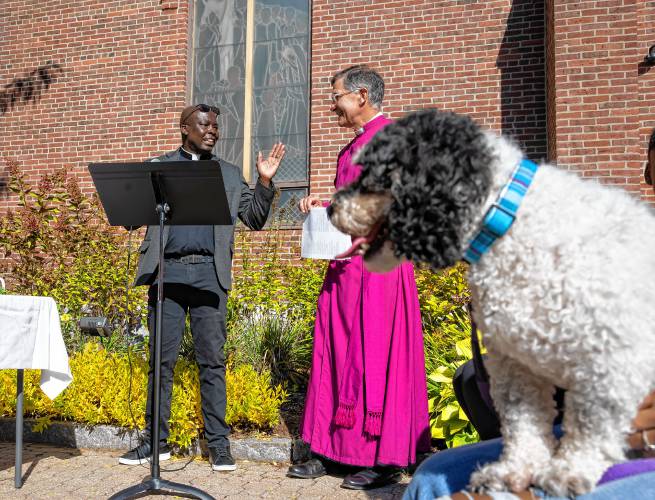 Rev. Jean Beniste, rector of St. Paul’s Church, leads the Blessing of the Animals service along with New Hampshire Bishop Robert Hirschfeld as the reverend’s dog, Charlie, waits to be blessed on Saturday in front of the church on Park Street.