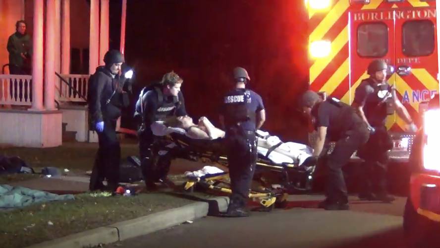 In a still frame from video first responders use a gurney to place an injured man into an ambulance while transporting him from the scene of a shooting, Saturday, Nov. 25, 2023, in Burlington, Vt. Burlington Police Department arrested Jason J. Eaton, suspected in the shooting of three young men of Palestinian descent, who were attending a Thanksgiving holiday gathering near the University of Vermont campus Saturday evening. (Wayne Savage via AP)