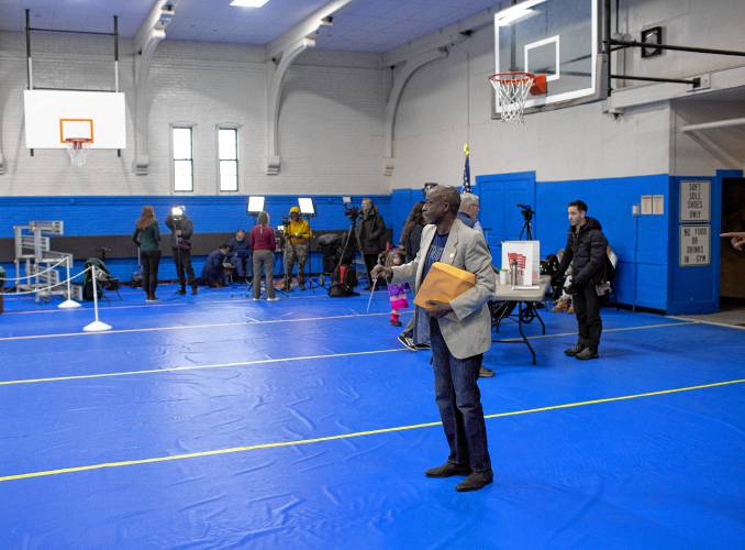 Kayitani Ndutiye waits in line at Ward 4 at the Green Street Community Center in Concord as he votes for the first time in the New Hampshire primary.