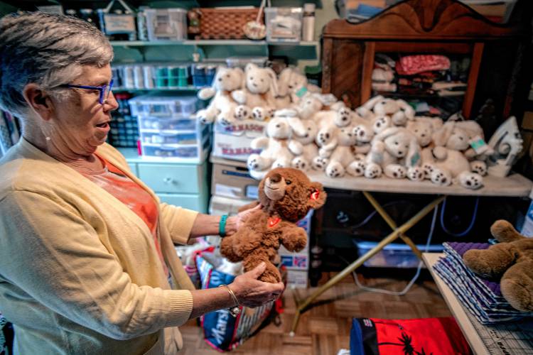 Nancy Peperissa in her sewing room in her Penacook home where she puts the finishing touches on making skull caps for chemotherapy patients and filling teddy bears with rice to comfort Alzheimer patients.