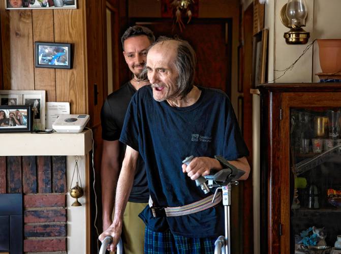 John Jones smiles as he completes a round of walking around using a walker his home in Franklin with the help of physical therapist Justin Levesque in April 29. By that time, Jones and his partner, Jessica Helfenstein, had bought back their house after it was seized by the city of Franklin. They remain in the home.