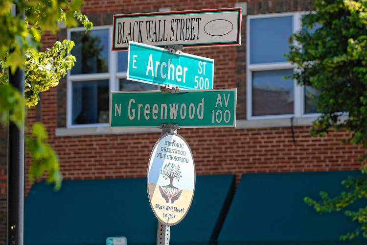 FILE - In this Monday, June 15, 2020, file photo, a sign marks the intersection of Greenwood Avenue and Archer Street, the former home of Black Wall Street, in Tulsa, Okla. 