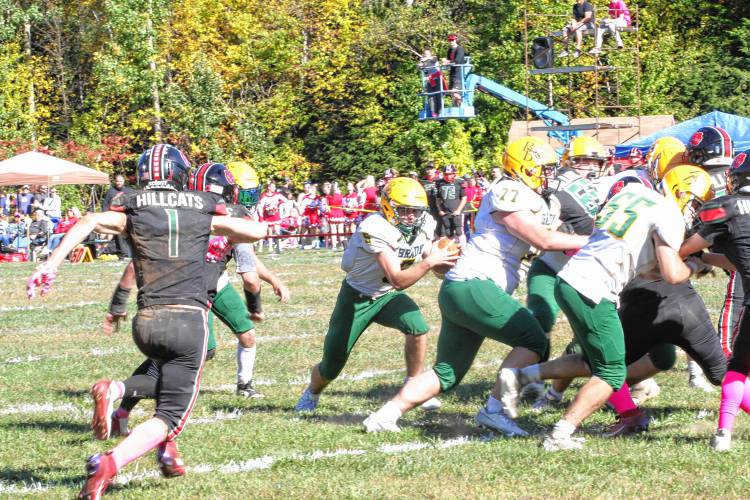 Bishop Brady quarterback Joey Richardson (5) rushes for an opening to the end zone thanks to great blocking from Bohden Esty-Lennon (77) and Luke Jackson (55) during the third quarter of Hillsboro-Deering's first ever homecoming game on its campus on Saturday, Oct. 5, 2024. Richardson scored three touchdowns on the ground and threw for three more at Bishop Brady defeated H-D, 56-46.