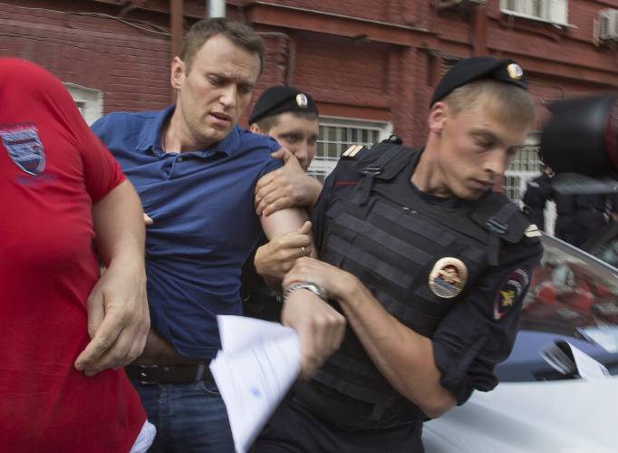 FILE - Police officers detain Russian opposition leader Alexei Navalny, left, in Moscow on July 10, 2013. Russia’s prison agency says that imprisoned opposition leader Alexei Navalny has died. He was 47. The Federal Prison Service said in a statement that Navalny felt unwell after a walk on Friday Feb. 16, 2024 and lost consciousness. (AP Photo/Alexander Zemlianichenko, File)