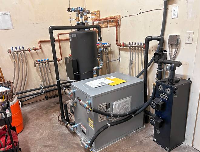 The new ground-source geothermal heat pump at Concord Quaker meetinghouse is much smaller than the pellet boiler system, freeing up space for storage.
