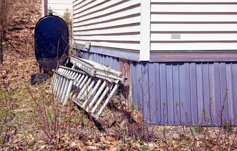 The ladders from John Jones painting business lean against his Franklin home. He is no longer working.