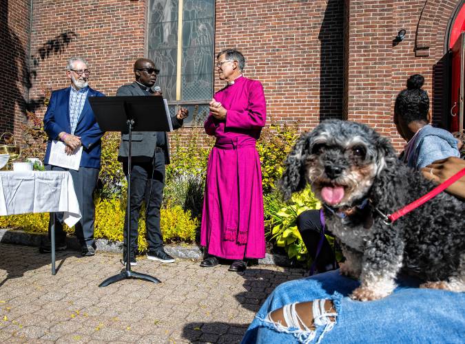 Rev. Jean Beniste (center), rector of St. Paul’s Church, leads the Blessing of the Animals service along with New Hampshire Bishop Robert Hirschfeld, with Concord Mayor Byron Champlin looking on. The reverend’s dog, Charlie, waits to be blessed on Saturday, October 5, 2024, in front of the church on Park Street.