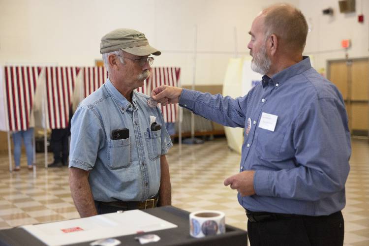 Bill Blewitt, right, places an “I Voted” sticker on Bob Porter’s shirt during New Hampshire primary voting in Claremont on Tuesday, Sept. 10. Bill Blewitt, right, places an “I Voted” sticker on Bob Porter’s shirt during New Hampshire primary voting in Claremont on Tuesday, Sept. 10.