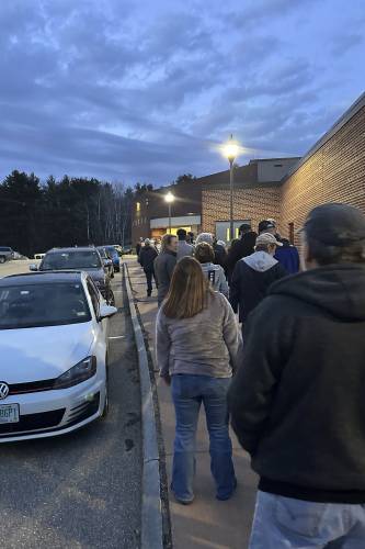 Residents line up outside the Inter-Lakes Middle/High School for the annual Meredith Town Meeting on March 13, 2024, in Meredith, N.H. An orchestrated effort to get rid of vote-counting machines from dozens of towns and return to hand-counting elections has failed. Just a single town opted to return to hand counts in a single race, the presidential election, in a decision that both the town's attorney and the secretary of state say is unlikely to stand. (AP Photo/Nick Perry)