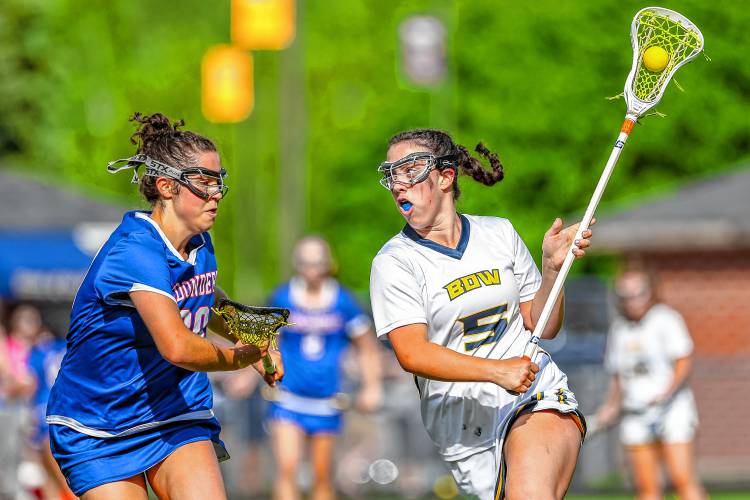 Bow's Charlotte Duncan (right) looks to move the ball upfield during the Falcons' 11-10 overtime win over Londonderry on Thursday, May 23, 2024.