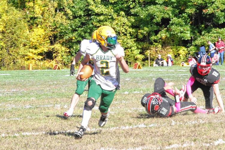 Bishop Brady running back Ian Miller (2) avoids tackles by Hillsboro-Deering's Andrew Abair (22) and Ethan Franklin (12) during the fourth quarter of H-D's first ever homecoming football game on its campus on Saturday, Oct. 5, 2024. Miller ran for two touchdowns and caught another in his first game back from injury. 