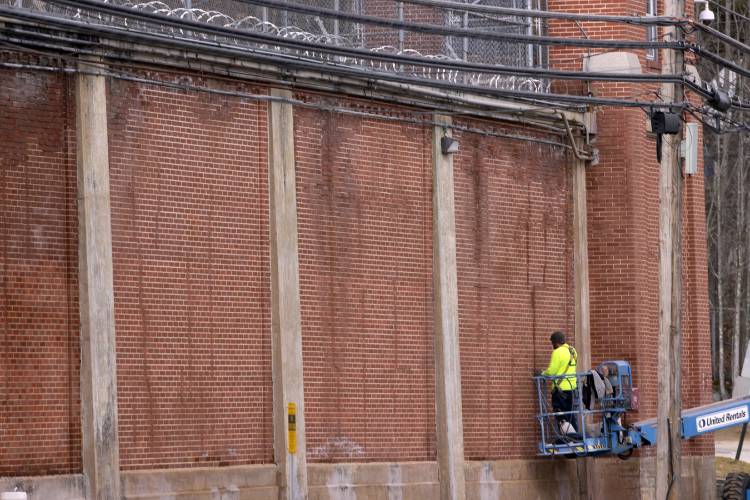 A worker uses a lift to work on the outside brick wall of the New Hampshire State Prison on North State Street on Wednesday, March 20, 2024. A worker uses a lift to work on the outside brick wall of the New Hampshire State Prison on North State Street on Wednesday, March 20, 2024.