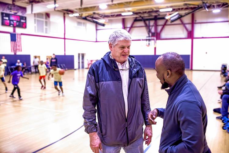 Bob Wolfe talks with Pascal Zabayo during a youth basketball game for New American kids at Abbot Downing School on Thursday night. Wolfe has known Pascal since he was 15, and now Zabayo helps mentor New Americans.