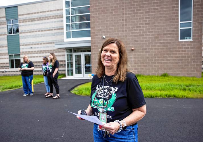 Allenstown Community School Principal Shannon Kruger directs as students and faculty gather for a drone photo outside the school on the first day of classes at the new facility.  Faculty wore black tee shirts commorating the first day of school and the students wore white tee shirts given by a school employee.