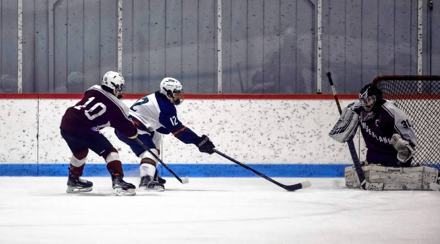 John Stark-Hopkinton/Hillsboro-Deering forward Ryan Podsadowski (center) shoots at the Timberline goalie during first period action on Wednesday.