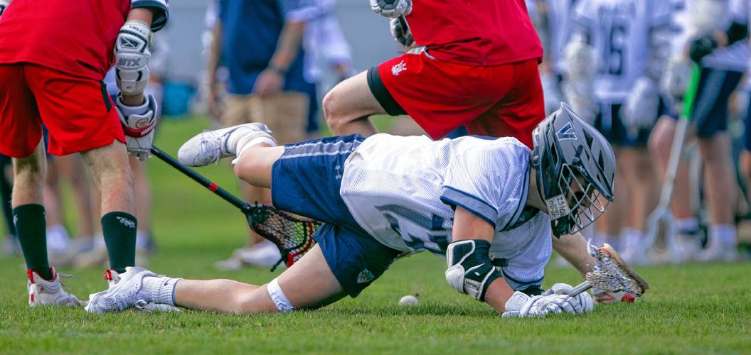 Merrimack Valley attacker Conner Hanson falls to the ground while dislodging the ball from two Spaulding defenders during the first half on Tuesday, April 16, 2024.