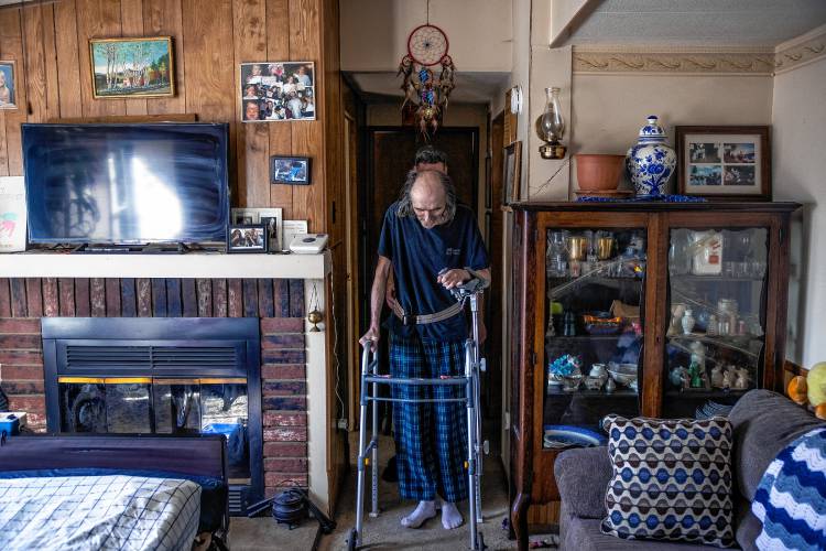 John Jones starts a round of walking around using a walker his home in Franklin with the help of his physical therapist Justin Levesque on April 29, 2024.