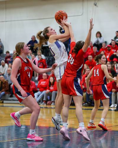 Concord Christian’s Emma Smith (center) rises for a jumper as John Stark’s Abby Duclos (30) contests the shot during last season’s Division II semifinal. Smith scored her 1,000th career point and was named to the All-State Second Team last season, and is back to help lead the Kingsmen this season.
